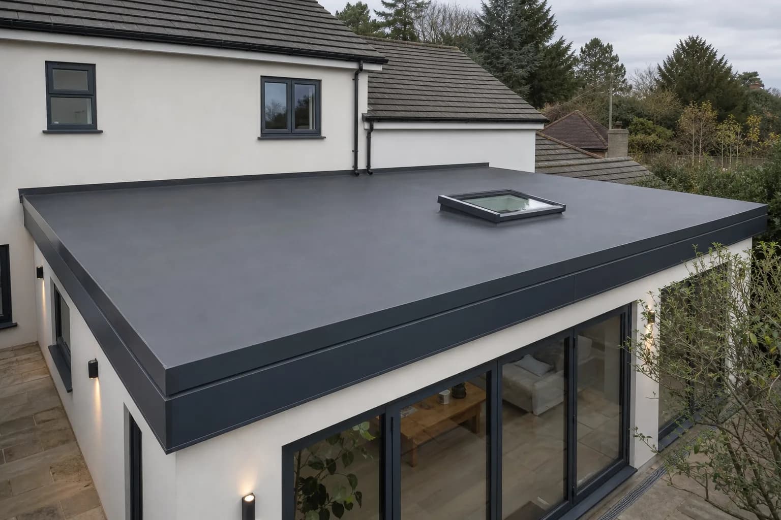 Black EPDM rubber flat roof on a single-storey house extension with clean edge trims and a rooflight